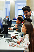 Teacher helping students using computer