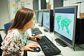 Curious school student looking at map on computer