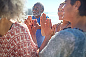 Friends with hands clasped in circle enjoying yoga retreat