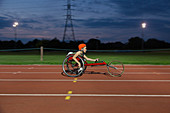 Teenage girl paraplegic athlete in wheelchair race at night