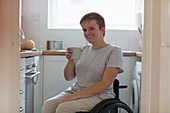 Portrait woman in wheelchair drinking tea