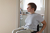 Thoughtful woman in wheelchair at home