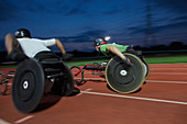 Paraplegic athletes during wheelchair race at night