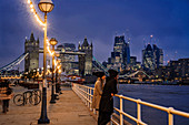 Couple standing along Thames River, London, UK