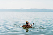Woman floating, swimming in Dead Sea, Jordan