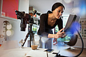 Female photographer working in studio, using digital tablet