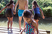 Family playing, jumping off dock into river