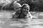 Happy couple swimming in river