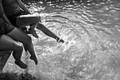 Mother and daughter splashing feet in river