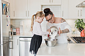 Mother and daughter baking in kitchen