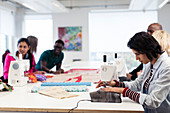 Fashion design students working at sewing machines