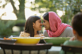 Affectionate mother in hijab rubbing noses