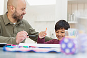 Father and son colouring at table