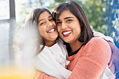 Portrait happy mother and daughter hugging