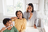 Portrait family brushing teeth in bathroom