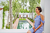 Laughing, carefree woman on hotel balcony