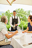 Wine steward showing wine bottle to couple