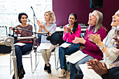 Happy women's choir singing in music recording studio