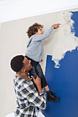 Father and son painting wall