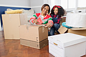 Mother and daughter taping moving boxes, moving house