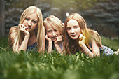 Portrait beautiful sisters laying in grass