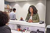 Smiling woman checking in at clinic reception