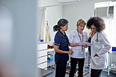 Female doctor and nurses using digital tablet