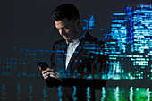 Businessman using smart phone at night