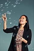 Businesswoman watching falling bubbles