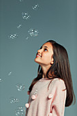 Happy, curious girl watching falling bubbles