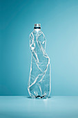Crumpled, empty plastic water bottle