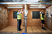 Male electrician students practicing in workshop