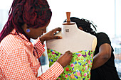 Female fashion designers pinning butterfly fabric