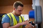 Male electrician student examining light switch