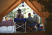 Family relaxing outside camping yurt