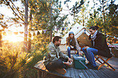 Friends playing cards outside yurt in woods