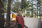Man hanging laundry on campsite clothesline