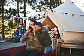 Father and son using binoculars at campsite