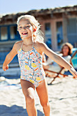 Carefree girl in bathing suit running on beach