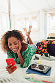 Young woman with smart phone relaxing on bed