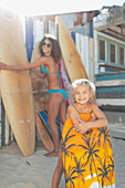 Mother and daughter with surfboard and boogie board