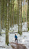 Woman jogging in snowy woods