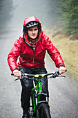 Man mountain biking in rain