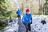 Father and son jogging in snowy woods