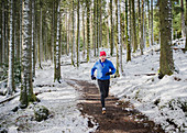 Senior man jogging in snowy woods
