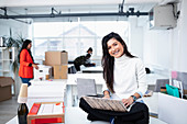 Smiling businesswoman using laptop in new office