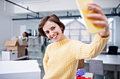 Confident businesswoman taking selfie in new office