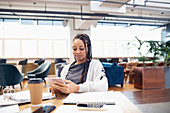 Businesswoman using digital tablet in open plan office