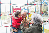 Grandparents playing with grandson at playground