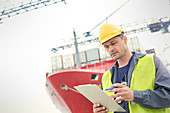 Dock worker below container ship at shipyard